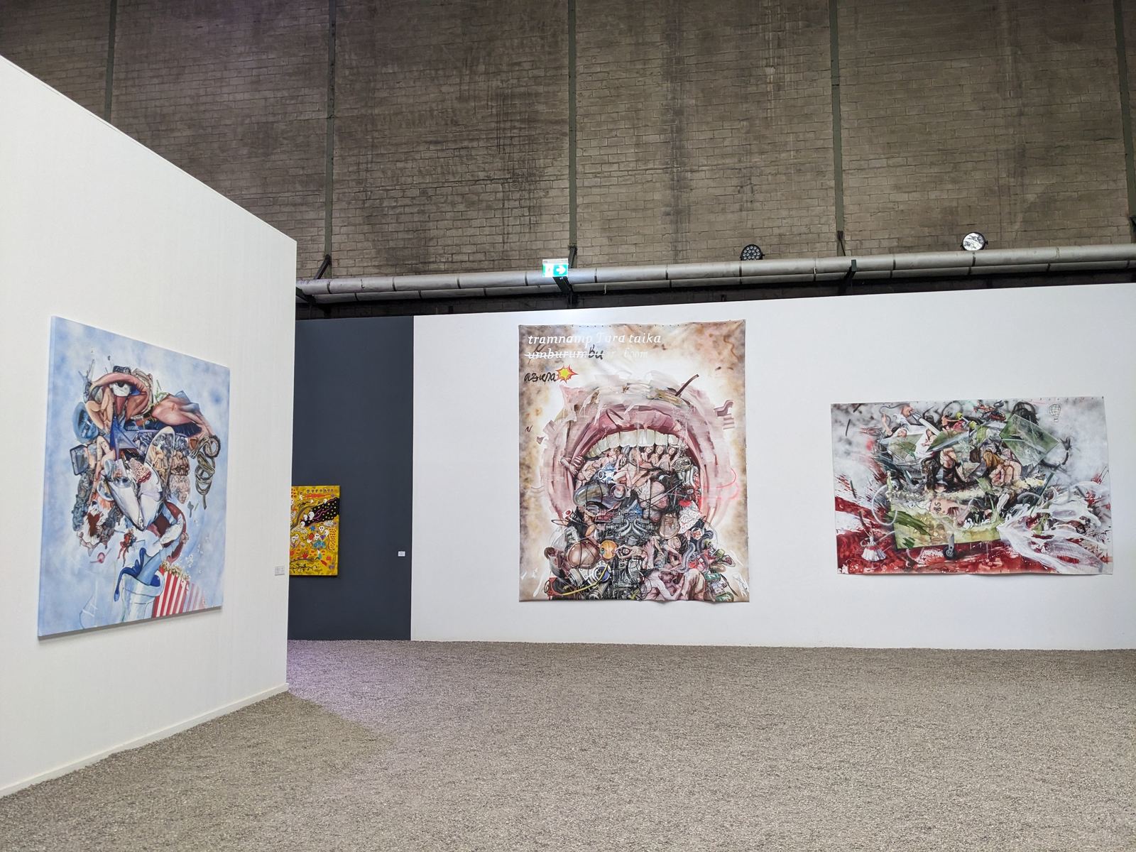 Ausstellungswand mit vier Werken nebeneinander: eine kreisförmige blaue Komposition, ein kleines gelbes Bild, das großformatige Mund-Werk und eine chaotische rot-weiße Flugzeugabsturz-artige Komposition