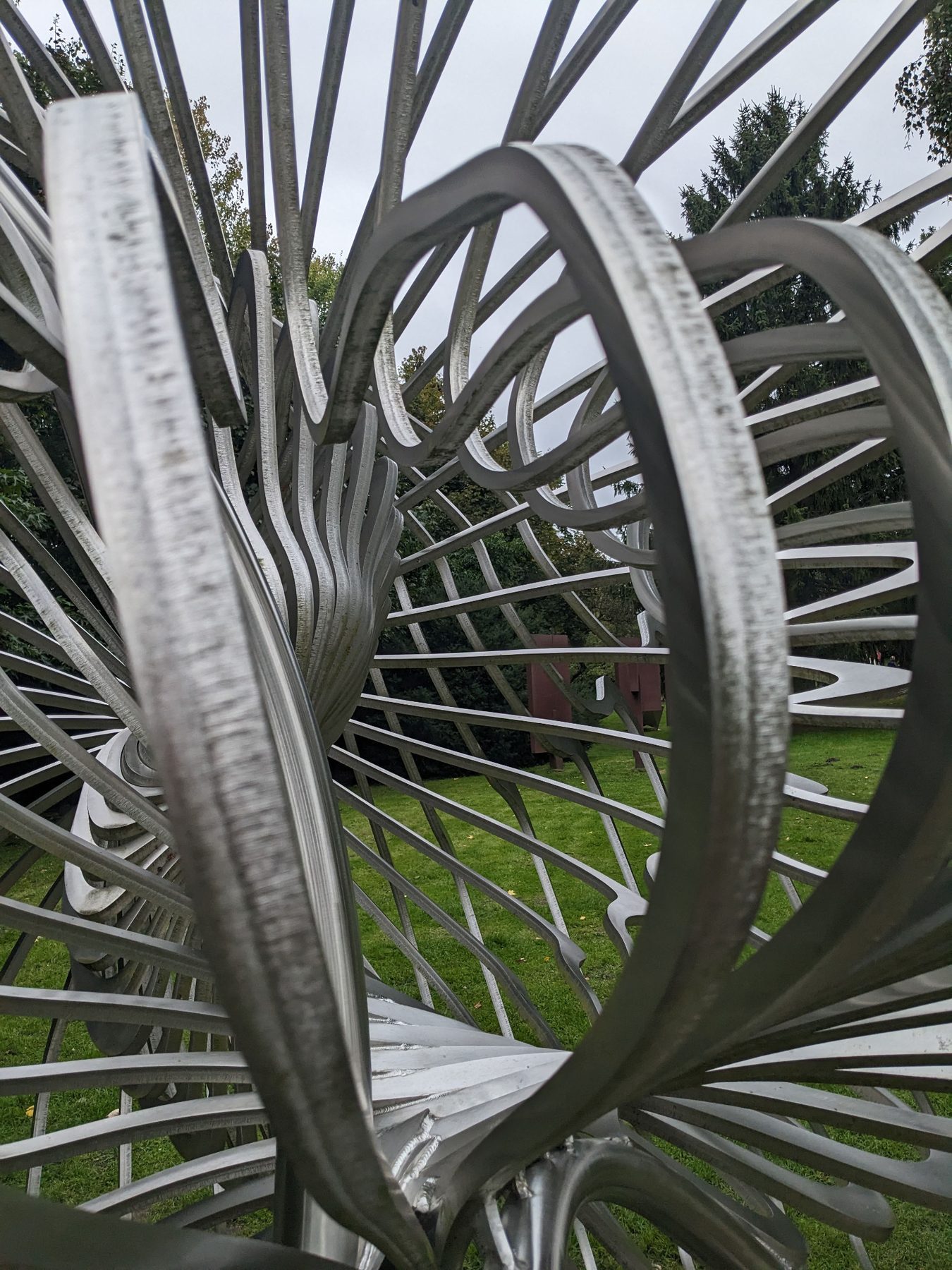 Nahaufnahme durch die gebogenen Edelstahlstreben von Jan Dostáls Skulptur Shell.