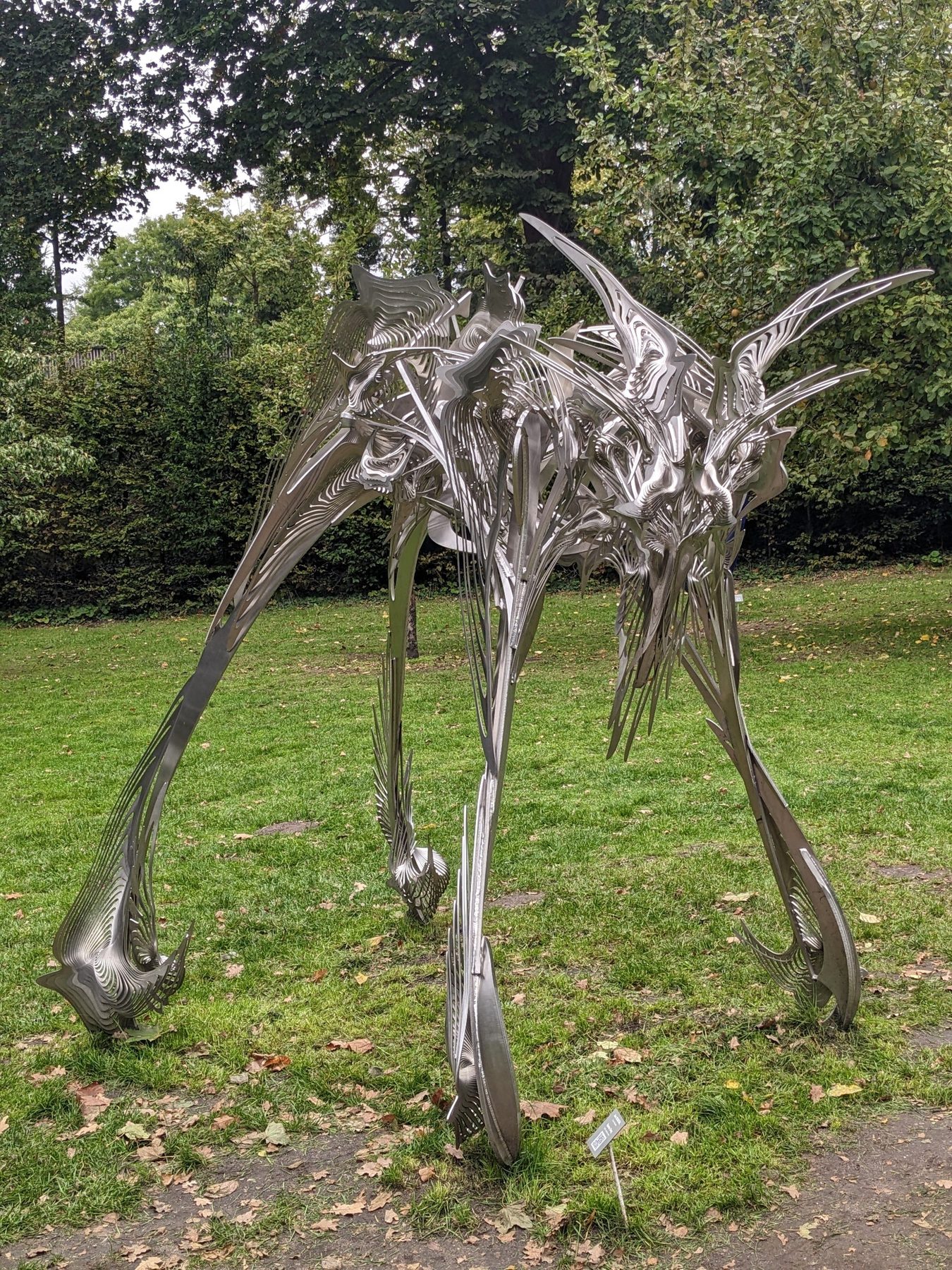 Gesamtansicht von Jan Dostáls Edelstahlskulptur Space Dog auf einer Rasenfläche.