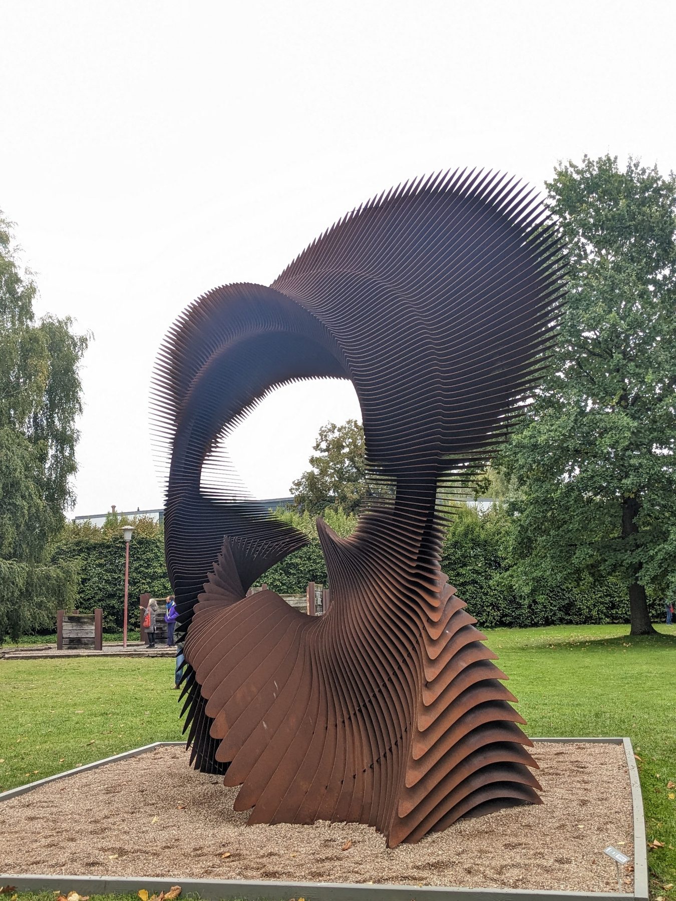 Toroid von Jan Dostál, eine große geschichtete Skulptur aus Cortenstahl.