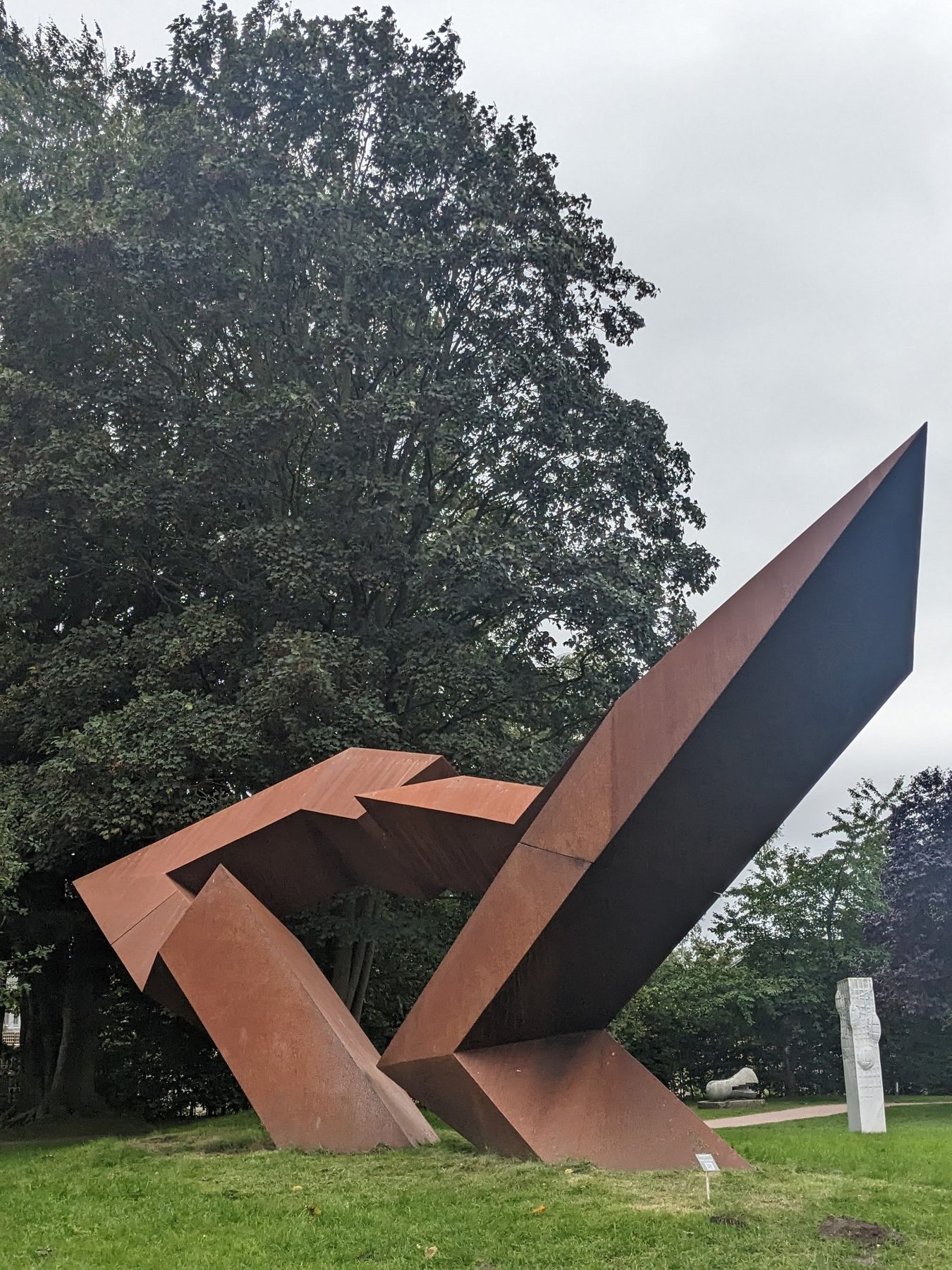 Seitliche Ansicht der kantigen Cortenstahl-Skulptur Dialogue Beyond Borders.