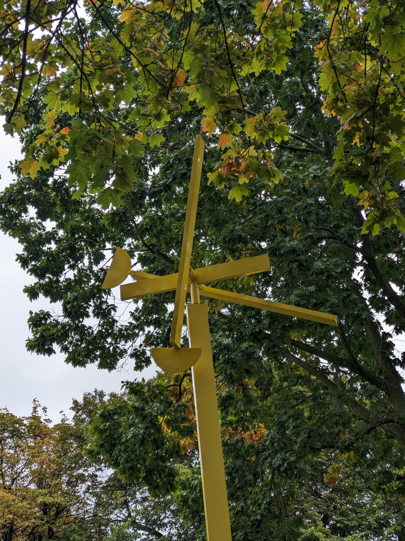Gelbe Skulptur WV311 von Michael Hischer zwischen den Baumkronen der NordArt