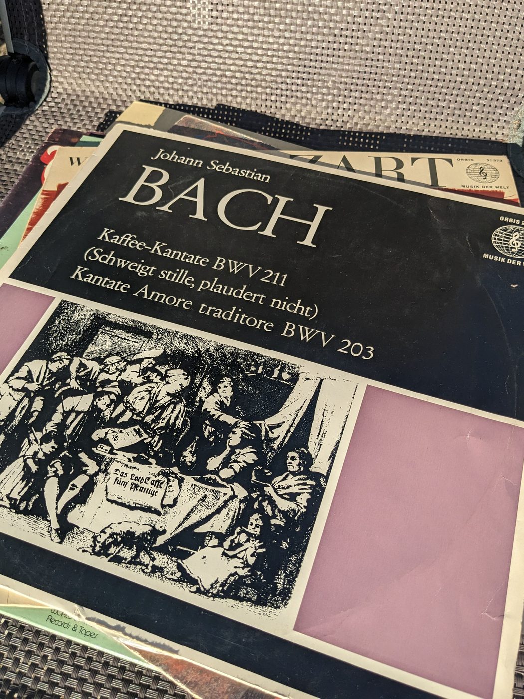 Johann Sebastian Bach – Kaffee-Kantate BWV 211 und Amore traditore BWV 203, schräg fotografiertes Detail der Vorderseite mit Werktiteln und historischer Illustration