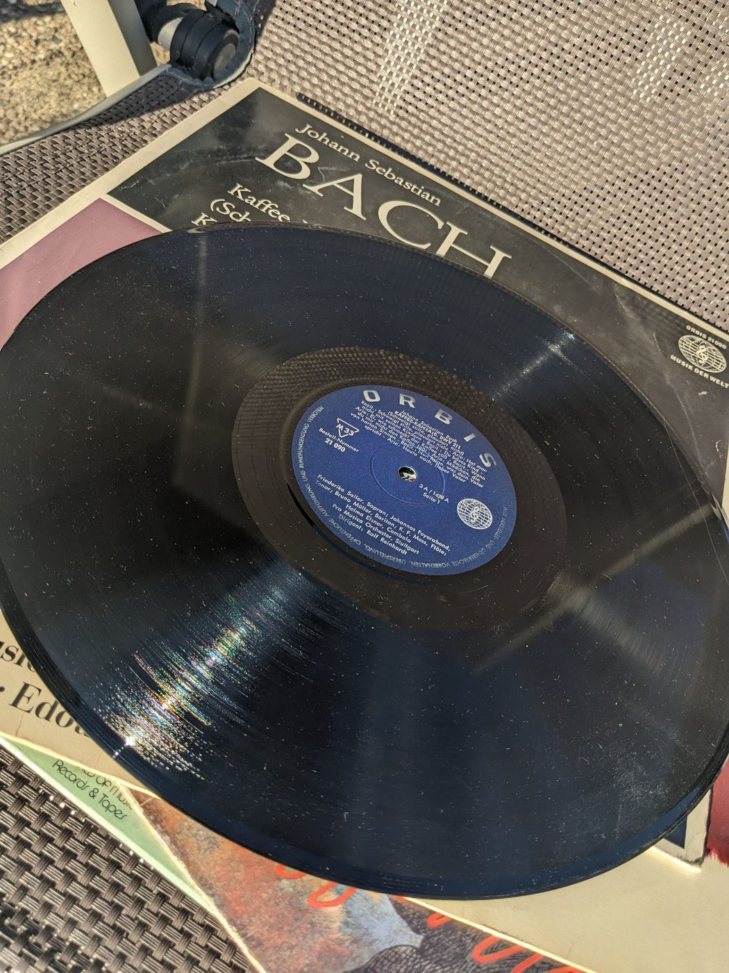 Johann Sebastian Bach – Kaffee-Kantate BWV 211 und Amore traditore BWV 203, schwarze Schallplatte mit blauem Orbis-Mittellabel vor der Plattenhülle