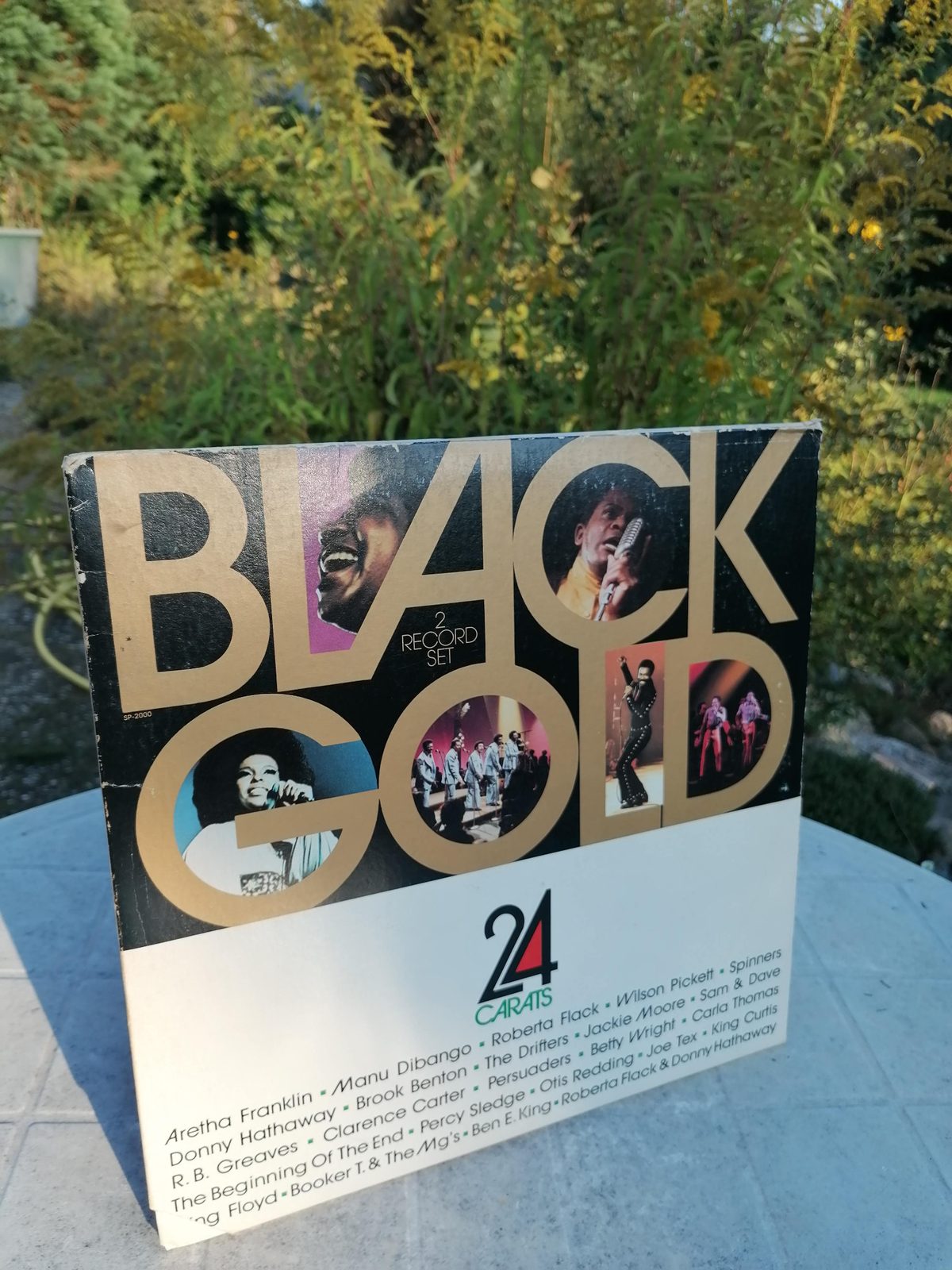 Frontcover des Doppelalbums Black Gold – 24 Carats mit großer goldener Schrift, mehreren Künstlerfotos und weißem unteren Bereich, im Freien fotografiert