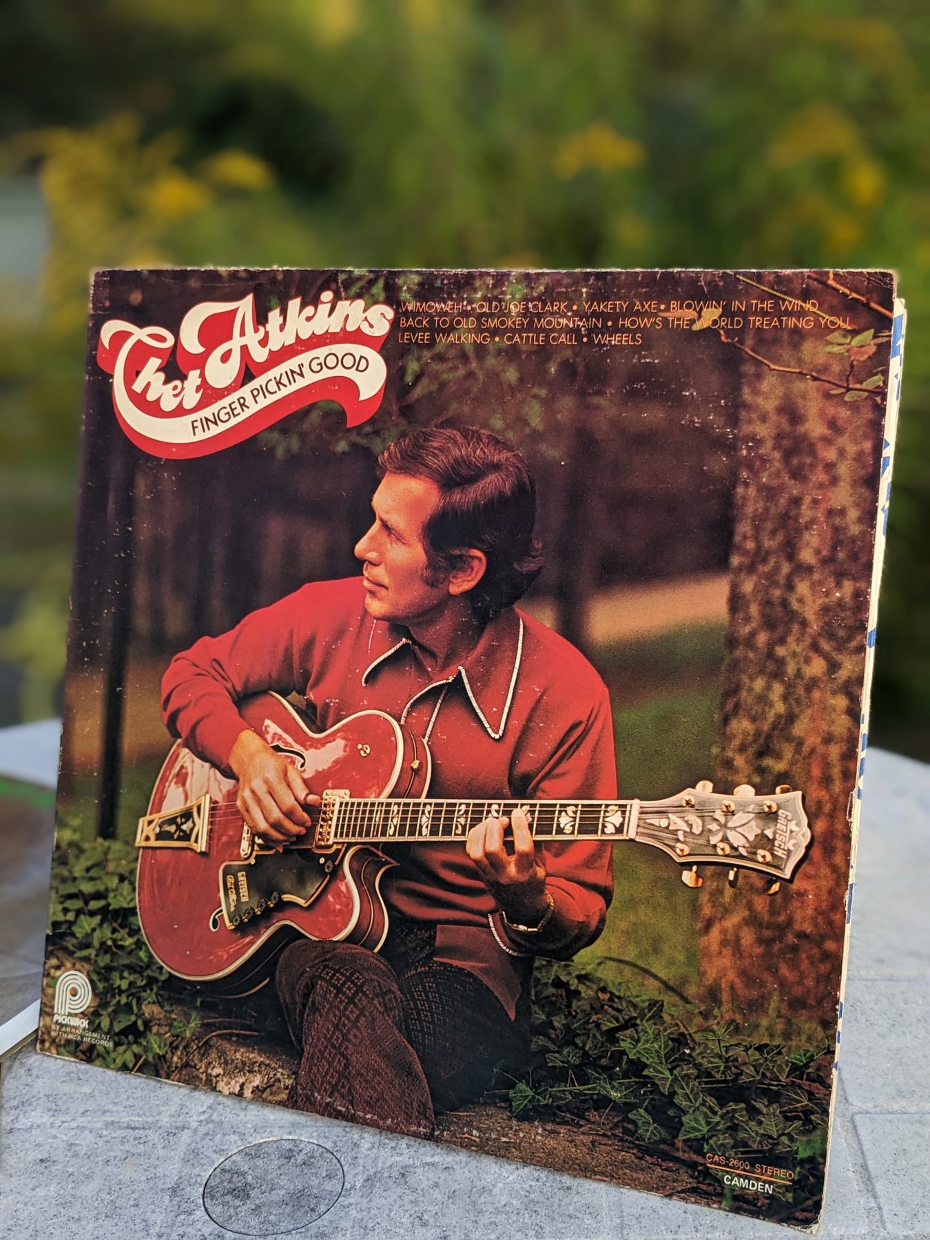 Vorderseite der LP-Hülle von Chet Atkins' Finger Pickin' Good mit Chet Atkins im roten Hemd und roter Gretsch-Gitarre vor einem Baum.